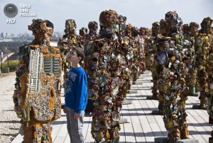 A boy looks at a statue by German artist HA Schult during a preview of the artist's exhibition at the Ariel Sharon Park near Tel Aviv